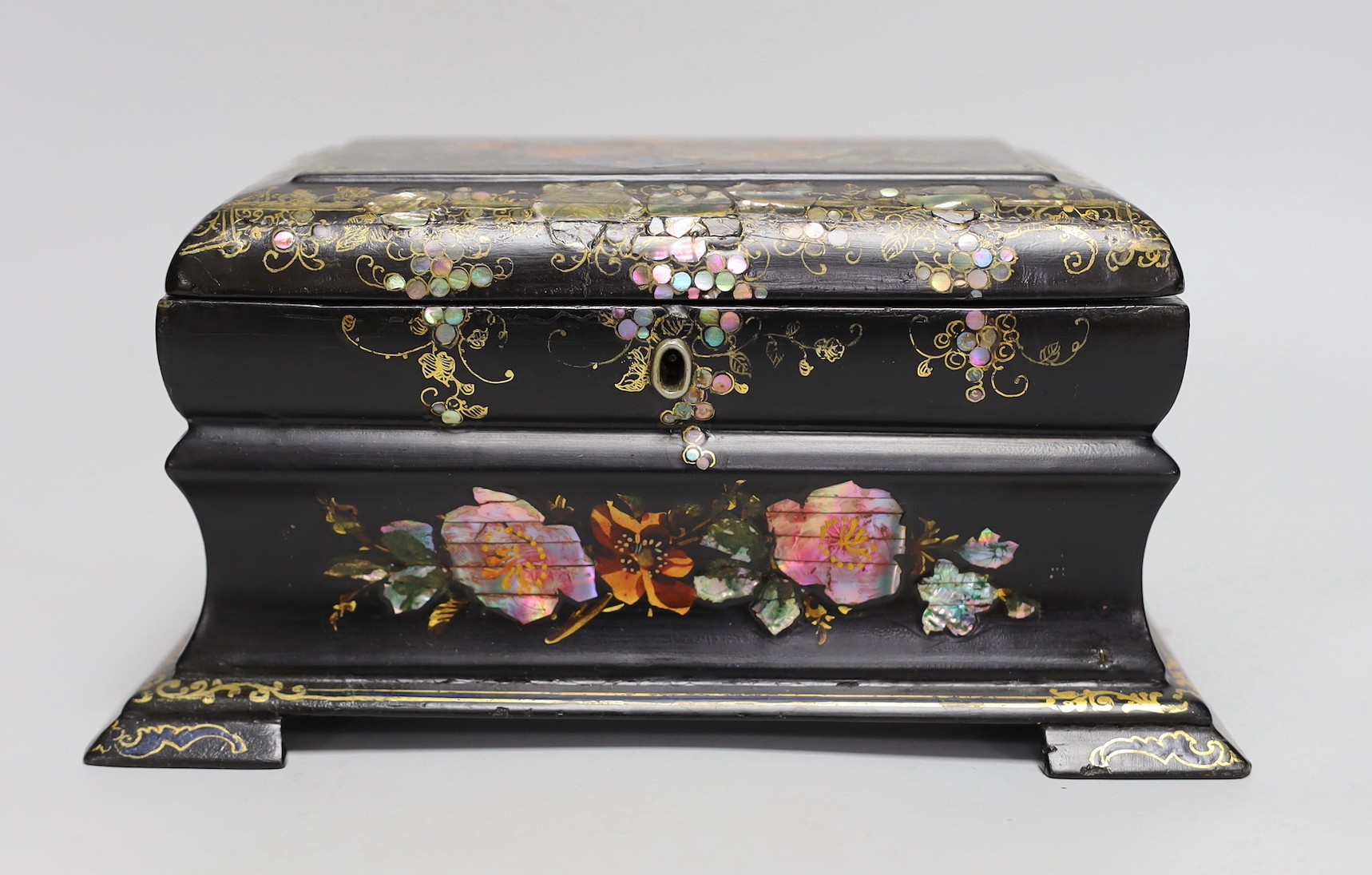 A Victorian painted and mother of pearl inlaid papier mache tea caddy. 23cm wide